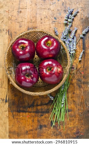 bouquet of lavender and red apples on a wooden background