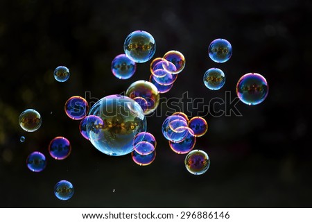 Rainbow soap bubbles on a dark background. Royalty-Free Stock Photo #296886146