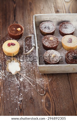 Chocolate  Mini Tartlets in vintage aluminium baking pan with dusting sugar
