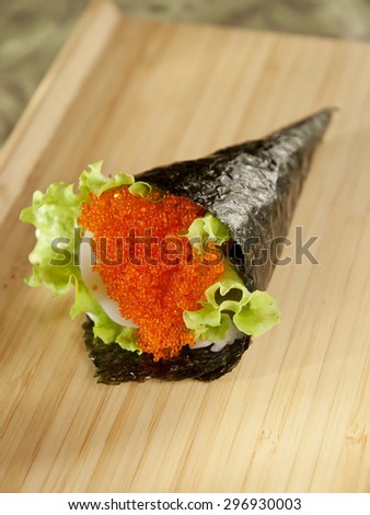 temaki with scallop and flying fish caviar on wooden board, vertical photo