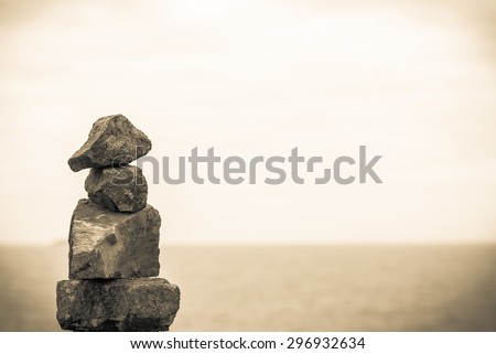 Stack of round smooth stones on a seashore. Business teamwork concepts. Seascape and blue sky.Vintage retro effect style pictures.