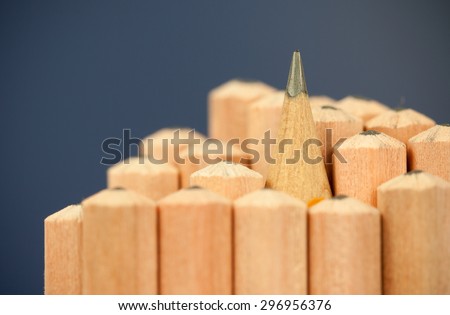 Macro image of graphite tip of a sharp ordinary wooden pencil as drawing and drafting tool, standing among other pencils, symbolizing individuality approach and concept as standing out from the crowd Royalty-Free Stock Photo #296956376