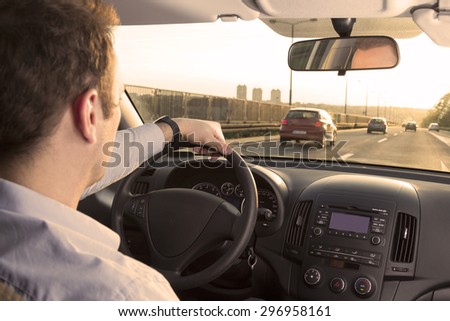 Businessman driving back home after exhausting day at work Royalty-Free Stock Photo #296958161