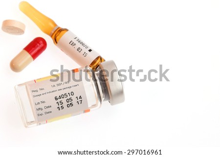 Expire Date label on medicine vial ampule with out of focus capsule and pill exp. Royalty-Free Stock Photo #297016961