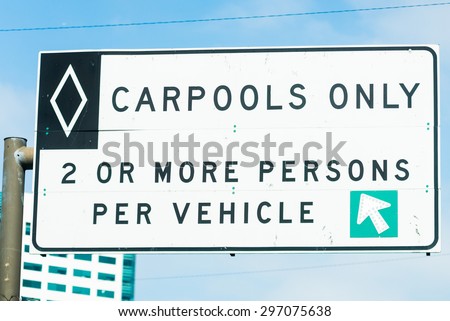Overhead freeway carpool only sign with blue sky
