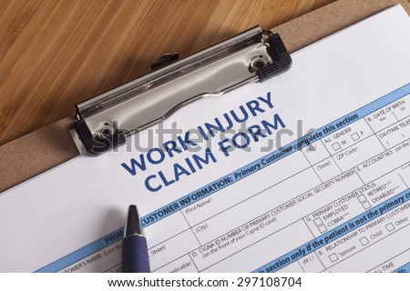 Claim form for a work injury on a desk top Royalty-Free Stock Photo #297108704