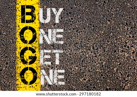 Concept image of Business Acronym BOGO as Buy One Get One  written over road marking yellow paint line. Royalty-Free Stock Photo #297180182