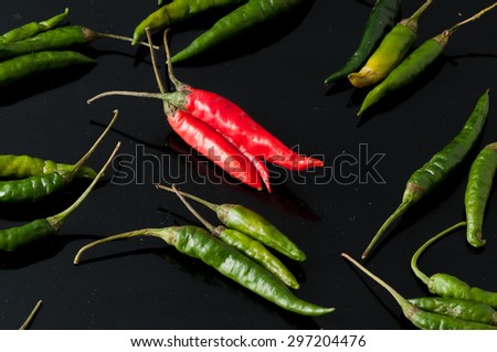 green chili peppers and red on a black background
