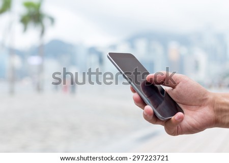 hand holding mobile phone on street