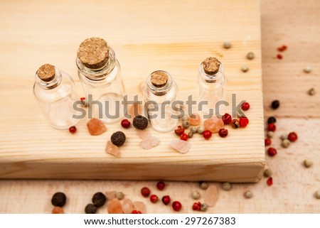 Spices and empty, small glass bottles with wooden texture