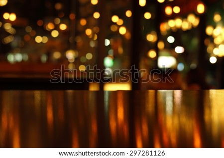 blur bokeh reflection light on table in pub or bar club and restaurant Christmas party and celebrate at dark night for display product in brown tone background  Royalty-Free Stock Photo #297281126