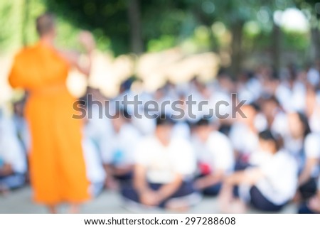 Student group meditation with monk in temple  defocused background. 