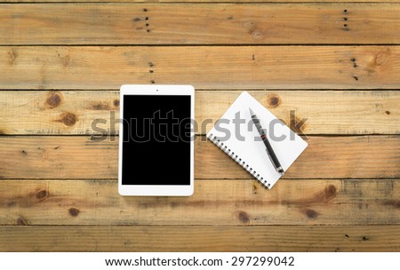 tablet and financial documents on wooden table