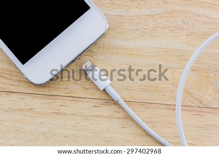 USB cable for smartphone on wood background.