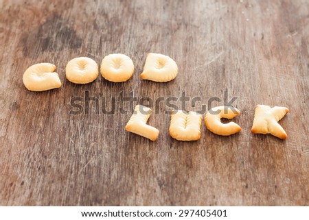 Good luck alphabet biscuit on wooden table, stock photo