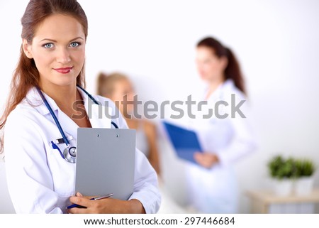 Smiling female doctor with a folder in uniform standing 