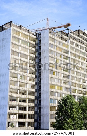 photo showing the demolition of a skyscraper with a high crane