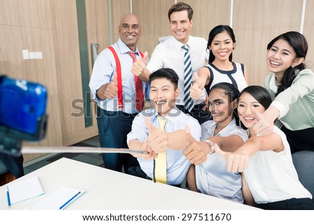 Business team taking picture with selfie stick