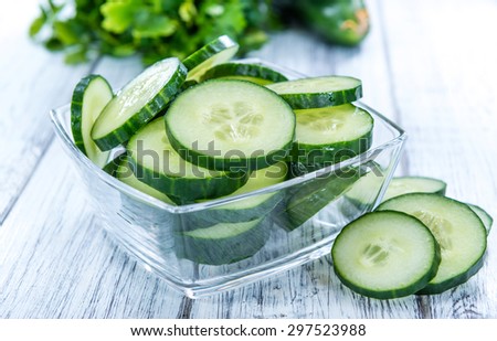 Heap of fresh sliced Cucumbers on an old wooden table Royalty-Free Stock Photo #297523988