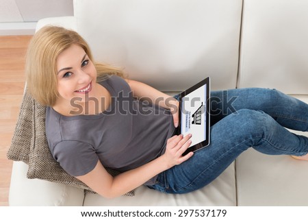 Young Happy Woman On Sofa Shopping Online With Digital Tablet At Home