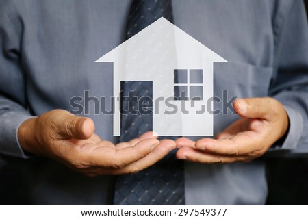  businessman use two hand hold house ,, business, technology, internet and networking concept - businessman pressing button with contact on virtual screens, personal loans and housing