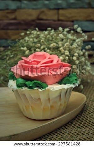 pink rose cupcake on wooden plates