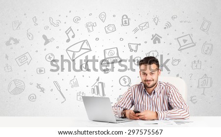 Business man sitting at table with hand drawn media icons and symbols