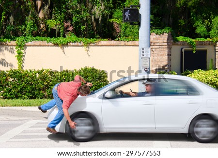 A man that is texting while driving runs over a pedestrian while the Cross Now sign is clearly visible showing that the pedestrian had the right of way. Royalty-Free Stock Photo #297577553