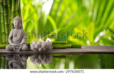 Buddha in meditation with burning candle Royalty-Free Stock Photo #297636071