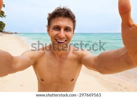 Tourist man beach taking selfie photo picture happy smile using smart phone summer vacation ocean paradise island travel 