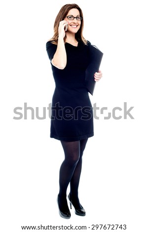 Corporate woman with files, talking on mobile phone. 