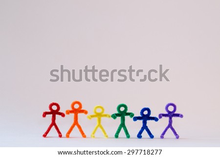 A row of rainbow colored, pipe-cleaner people. Great for international and multicultural purposes. With a white background, this photo has many applications for multiple ideas and concepts. 
