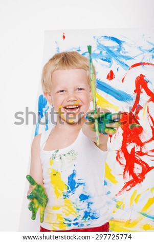 Little messy kid painting with paintbrush picture on easel. Education. Creativity. School. Preschool. Studio portrait over white background.