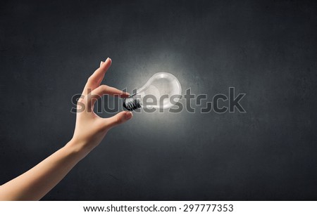 Close up of woman hand holding glass light bulb