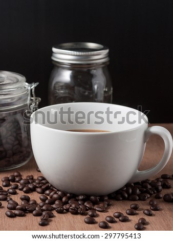 Coffee cup and coffee beans on wood background