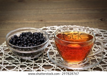 Glass Tea Cup With Herbal Tea,  Retro Gold Spoon And Plate With Blueberries On The Rustic Rough Wooden Table Background