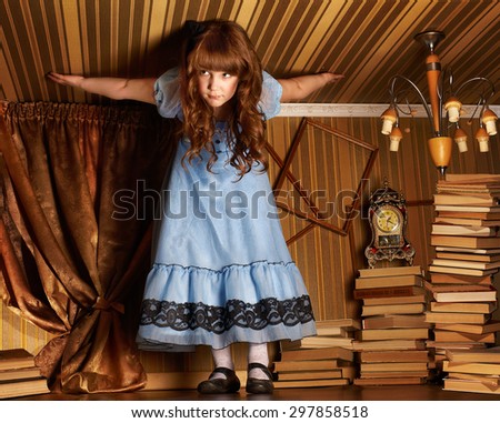 Little girl in a blue dress on the floor in a little room