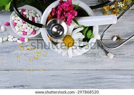 Alternative medicine herbs, berries and stethoscope on wooden table background Royalty-Free Stock Photo #297868520