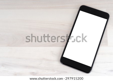 Smartphone on wooden table on light background