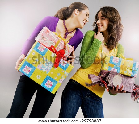 Two happy young girls holding presents