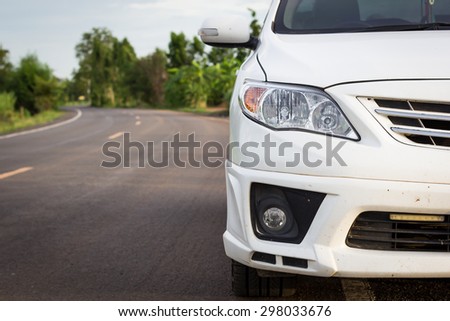 front of dirty white car parking on the asphalt road Royalty-Free Stock Photo #298033676