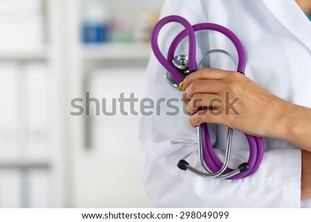 Female medicine doctor standing with hands crossed on her chest closeup. Medical help or insurance concept. Doctor is waiting for patient to examine. Physician reception concept
