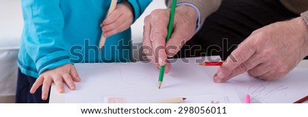 Child and grandfather coloring the image together