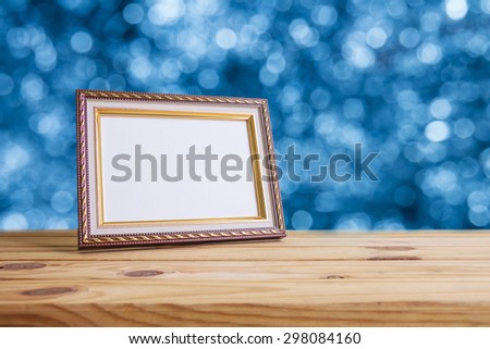Vintage photo frame on wooden table over bokeh background