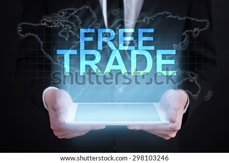 Businessman holding a tablet pc with "Free trade" text on virtual screen. Internet concept. Business concept.