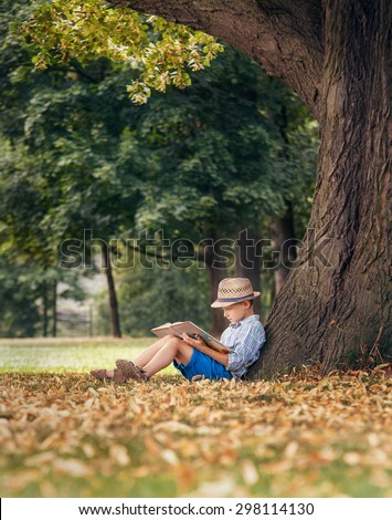 Boy reading under the big linden tree