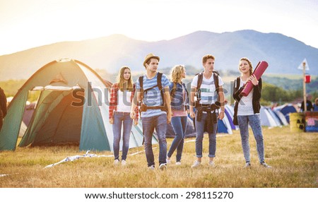 Group of beautiful teens arriving at summer festival Royalty-Free Stock Photo #298115270