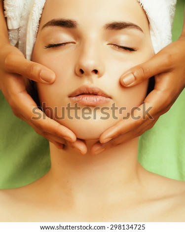 stock photo attractive lady getting spa treatment in salon, close up asian tan hands on face 