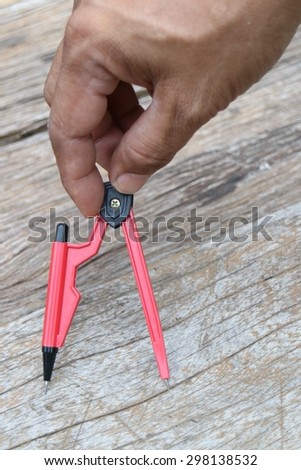 compasses red on wooden background                              