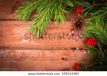 Wooden background with pine tree branch and red berries. Christmas concept. Thanksgiving concept.  